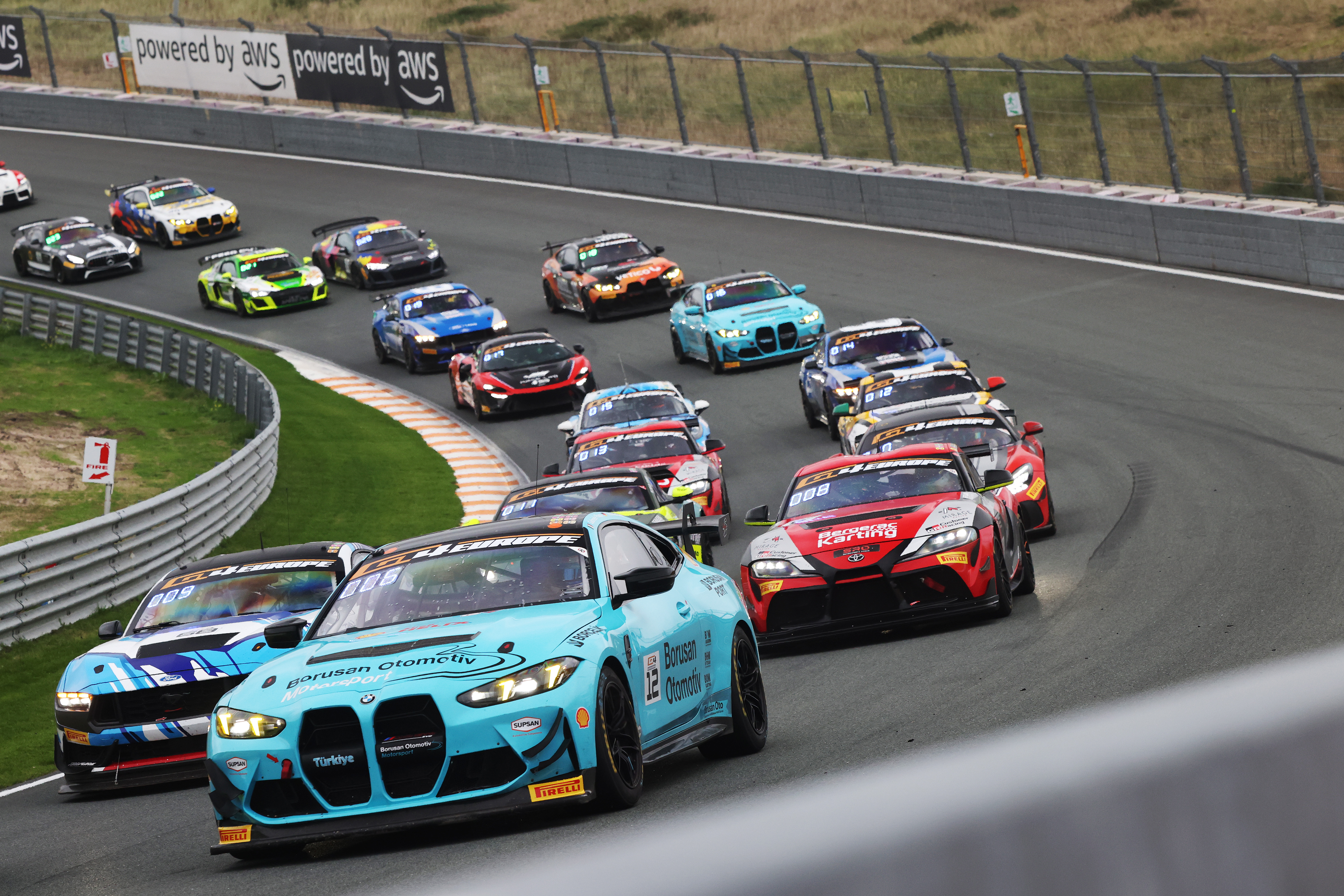 12 numaralı turkuaz BMW M4 GT4 Evo ilk yarışta Zandvoort virajında GT4 grubunun önünde