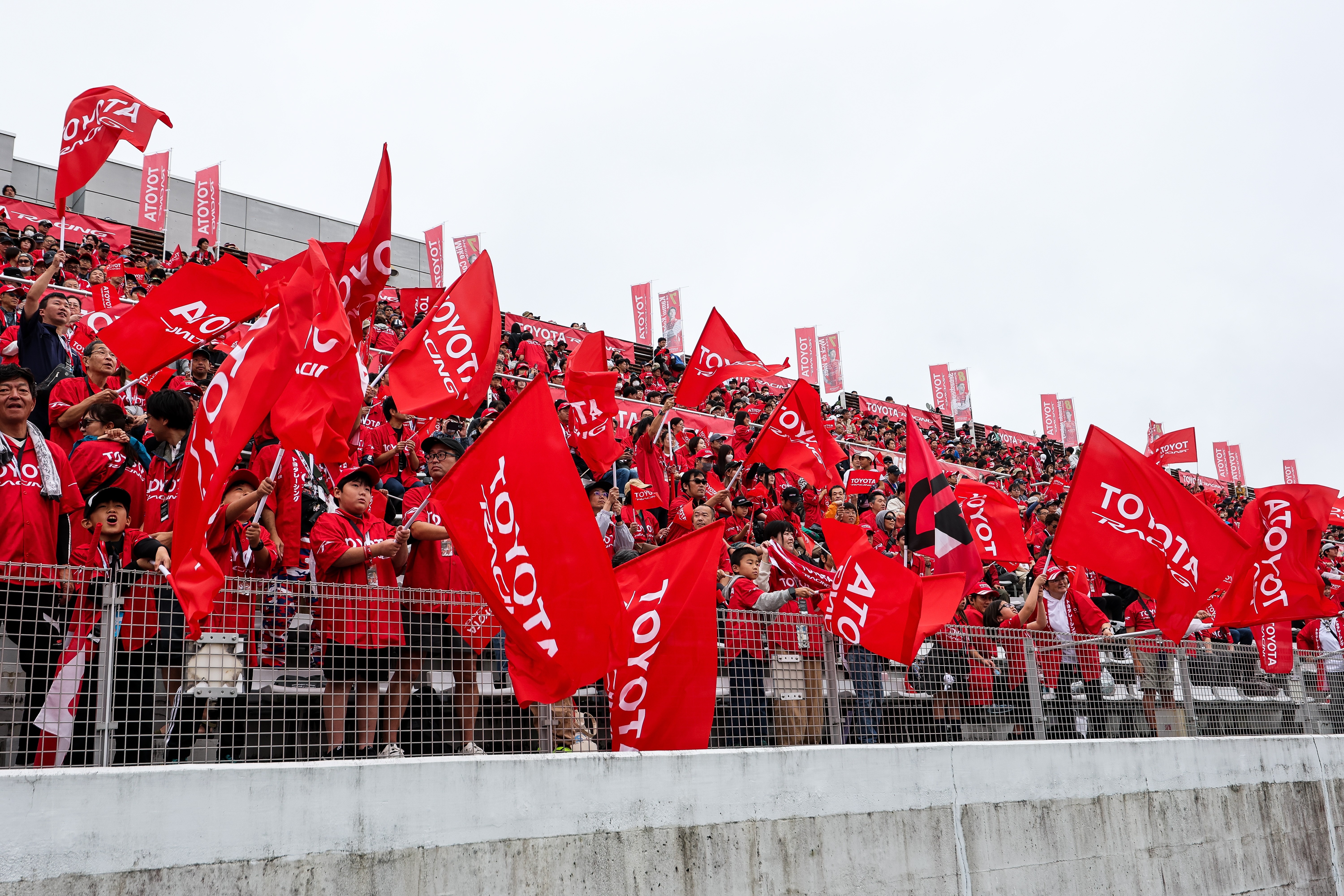 Fuji Speedway tribünlerinde Toyota bayraklarıyla yarışı izleyen seyirciler