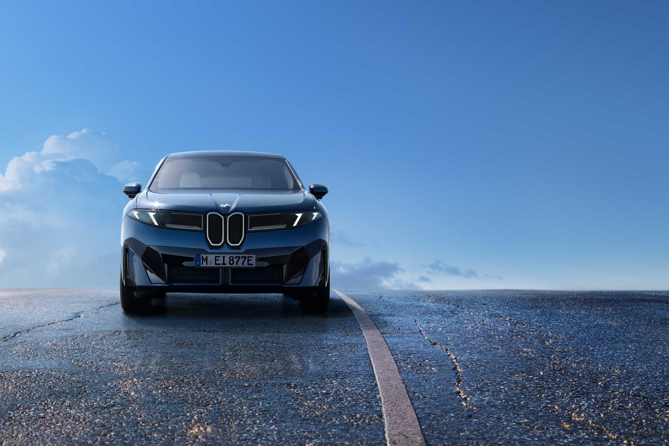 Lacivert iX3 50 xDrive'ın açık gökyüzü altında önden görünümü
