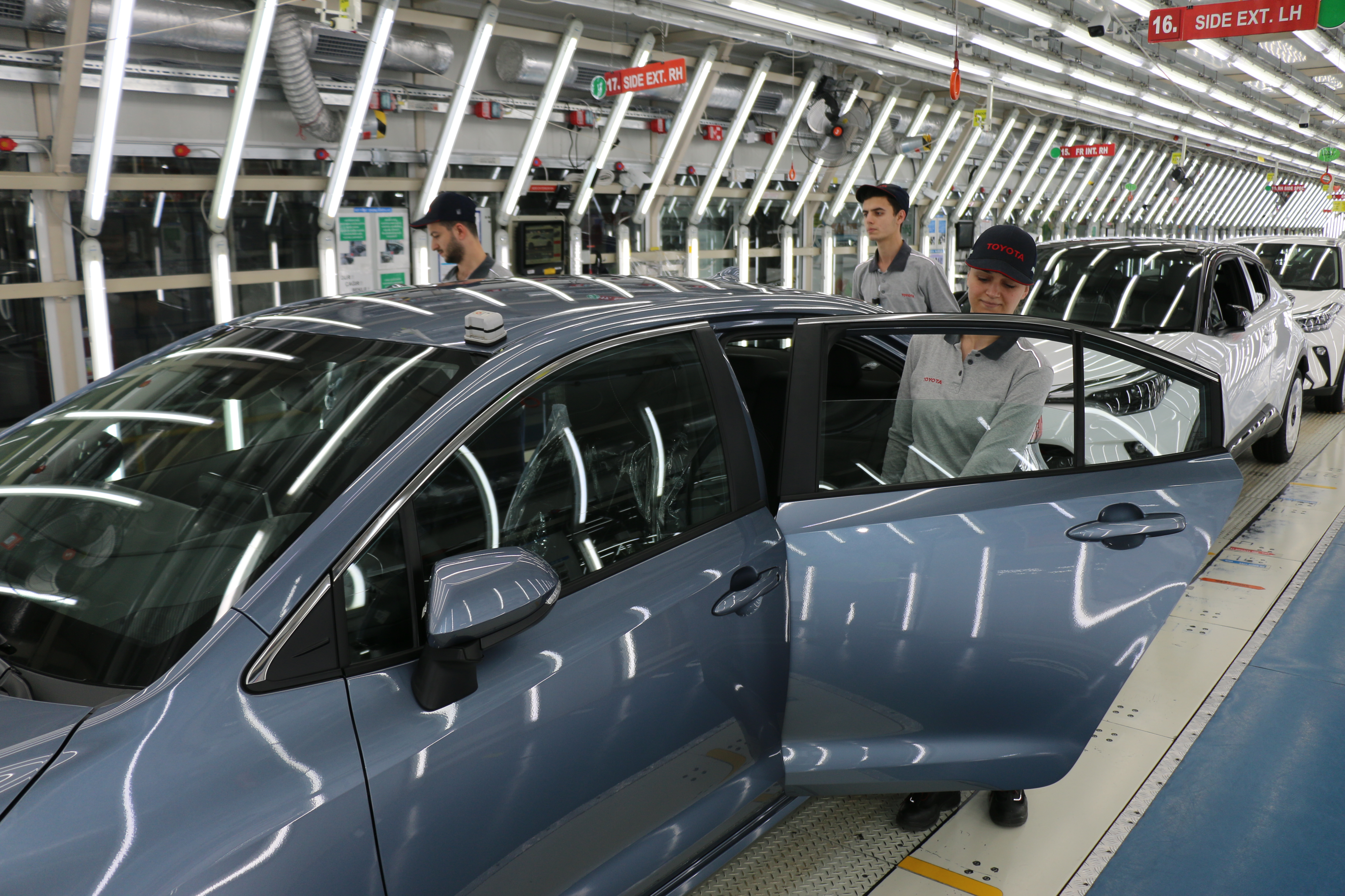 Toyota Sakarya fabrikasının montaj hattında ilerleyen sedan gövdeleri ve çalışanlar