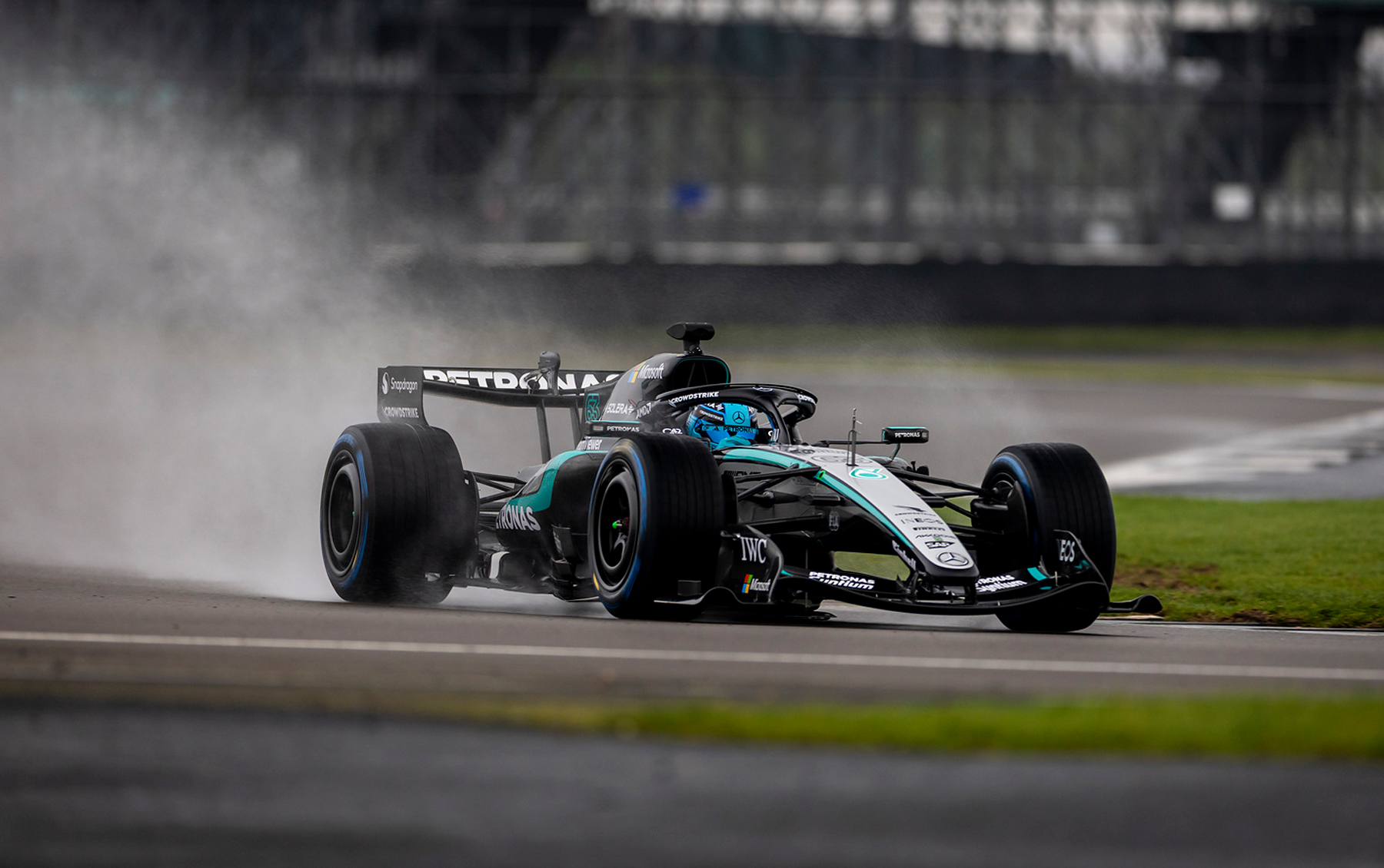 Toto Wolff'un takımına ait Mercedes W17 ıslak pistte su bulutu bırakırken