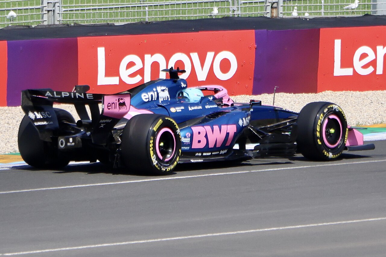 Alpine A526 Formula 1 otomobili yandan görünümde, pist üzerinde hızla ilerliyor