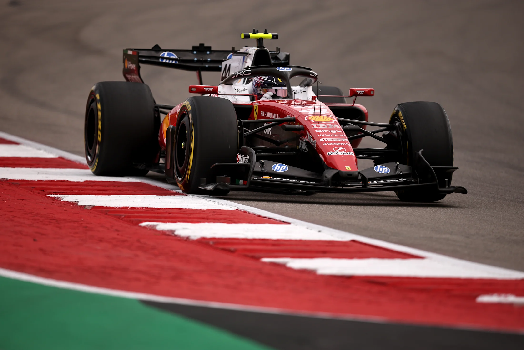 Austin'de Circuit of The Americas virajında kerbi kullanarak ilerleyen kırmızı beyaz Ferrari Formula 1 otomobili