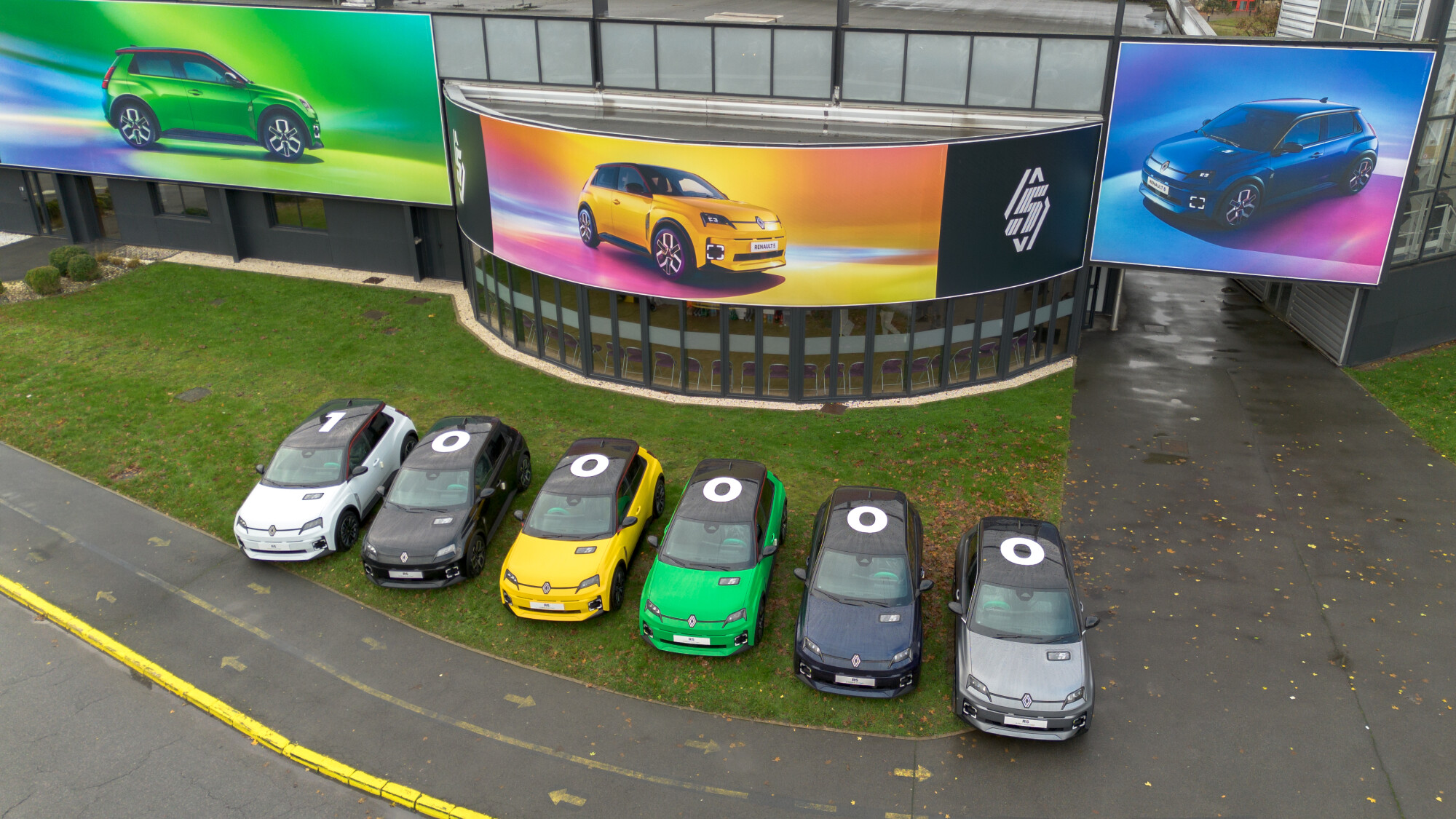ElectriCity tesisinin önünde farklı renklerde dizilmiş altı adet Renault 5 E-Tech elektrikli otomobil