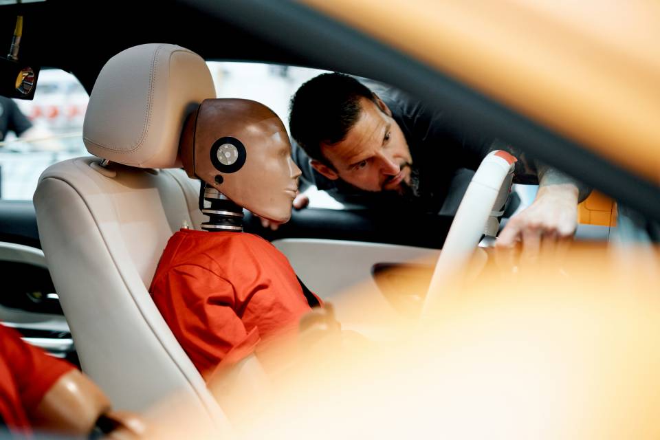 Çarpışma testi mankeni, bir Mercedes CLA içinde sürücü koltuğunda ve bir teknisyen tarafından kontrol ediliyor