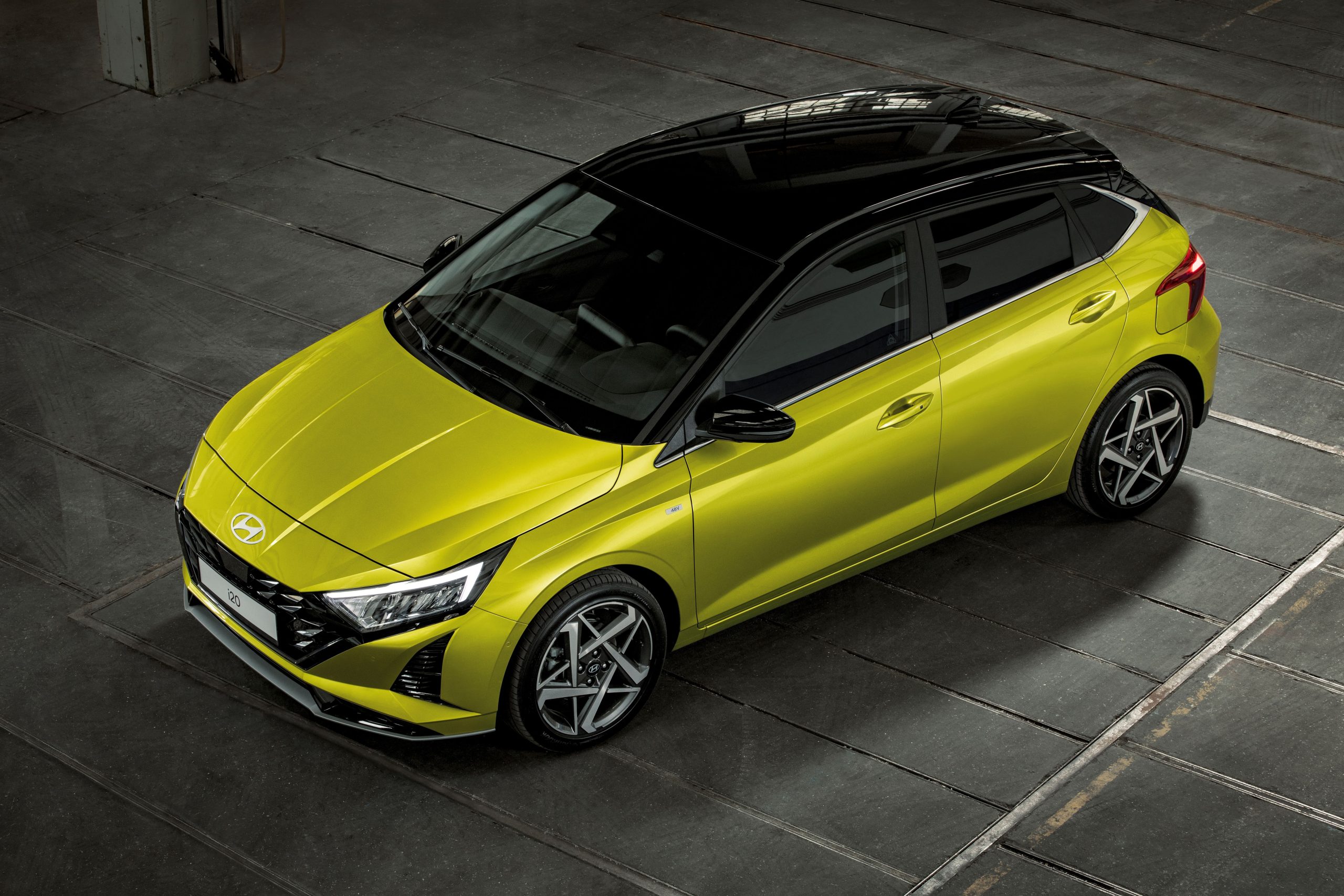 Sarı gövdeli Hyundai i20'nin üstten önden üç çeyrek görünümü