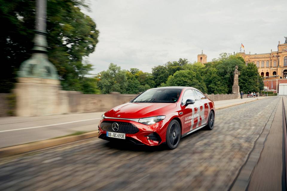 Kırmızı Mercedes-Benz, sokakta ön cepheden ve hareket hâlinde fotoğraflanmış