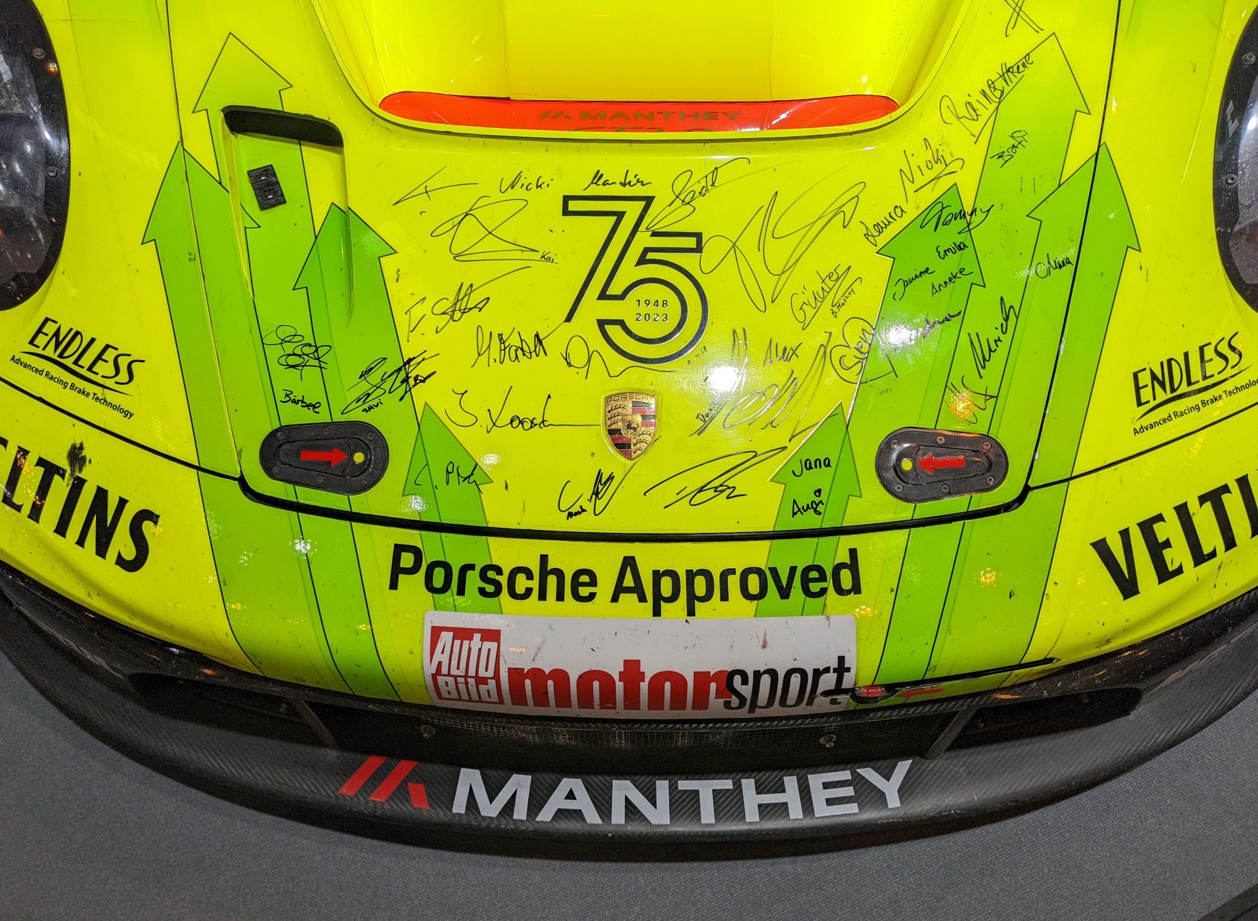 Manthey takımının Porsche 911 GT3 R otomobilinin kaputu üzerindeki imzalar ve Manthey yazısı yakından görülüyor