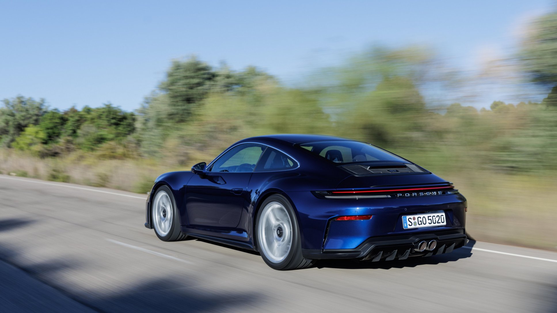 Mavi renkli Porsche 911 GT3 Touring Paketi modelinin arkadan hareket hâlindeki görünümü