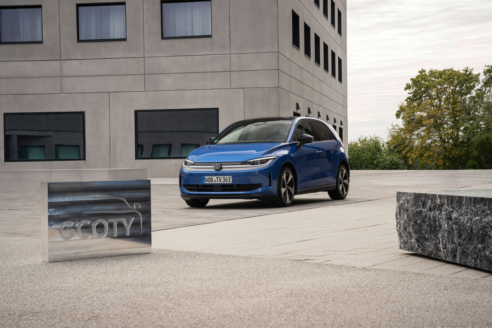 Mavi renkli Volkswagen ID. Polo hatchback otomobilinin bir binanın önünde yandan görünümü