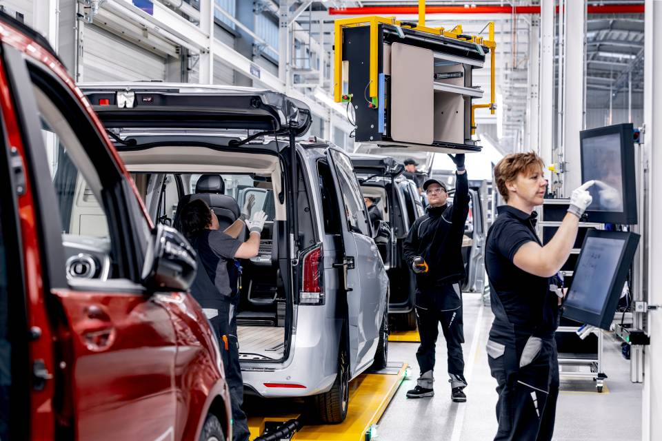 Mercedes Marco Polo üretim bandında çalışanlar bagaj kapağı açık otomobilin iç donanımını monte ediyor