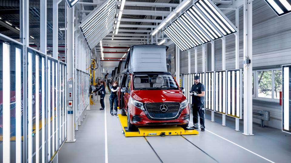 Mercedes Marco Polo üretim salonunun uzun bandı boyunca ilerliyor ve çalışanlar bandın iki yanında görev yapıyor