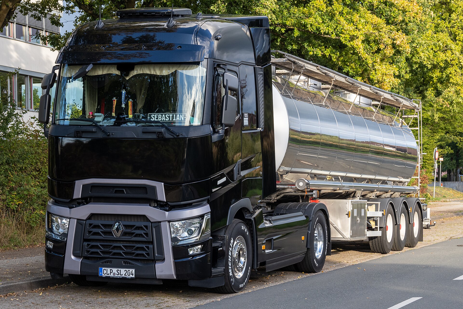 Siyah Renault Trucks T High 520 çekici, tanker yarı römorkla birlikte yolda görünüyor