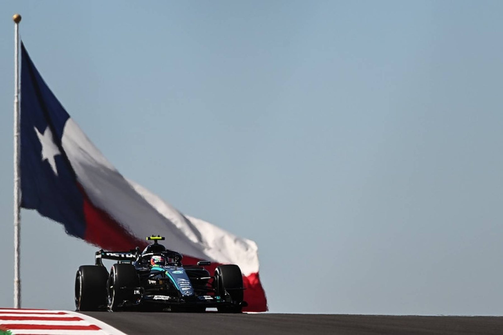 Teksas bayrağının önünde tepeyi aşan Mercedes W17