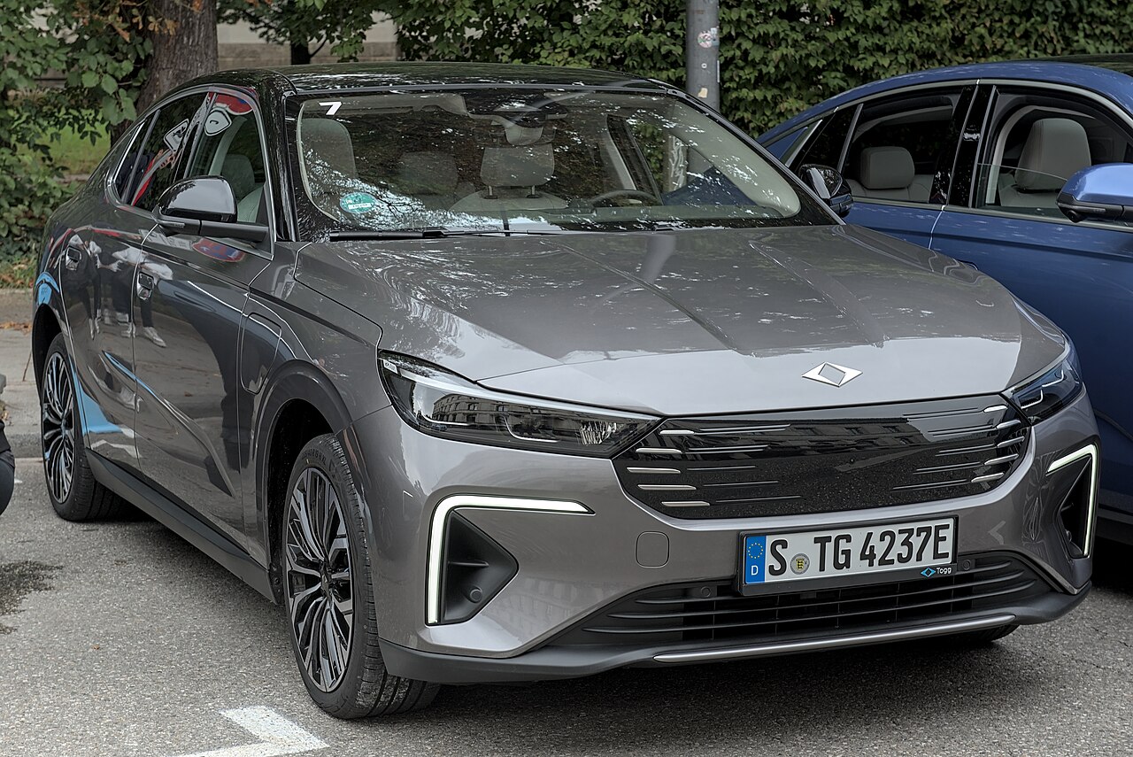 Togg T10F modelinin IAA 2025 etkinliğinde açık alanda park hâlindeki gri gövde renkli örneği