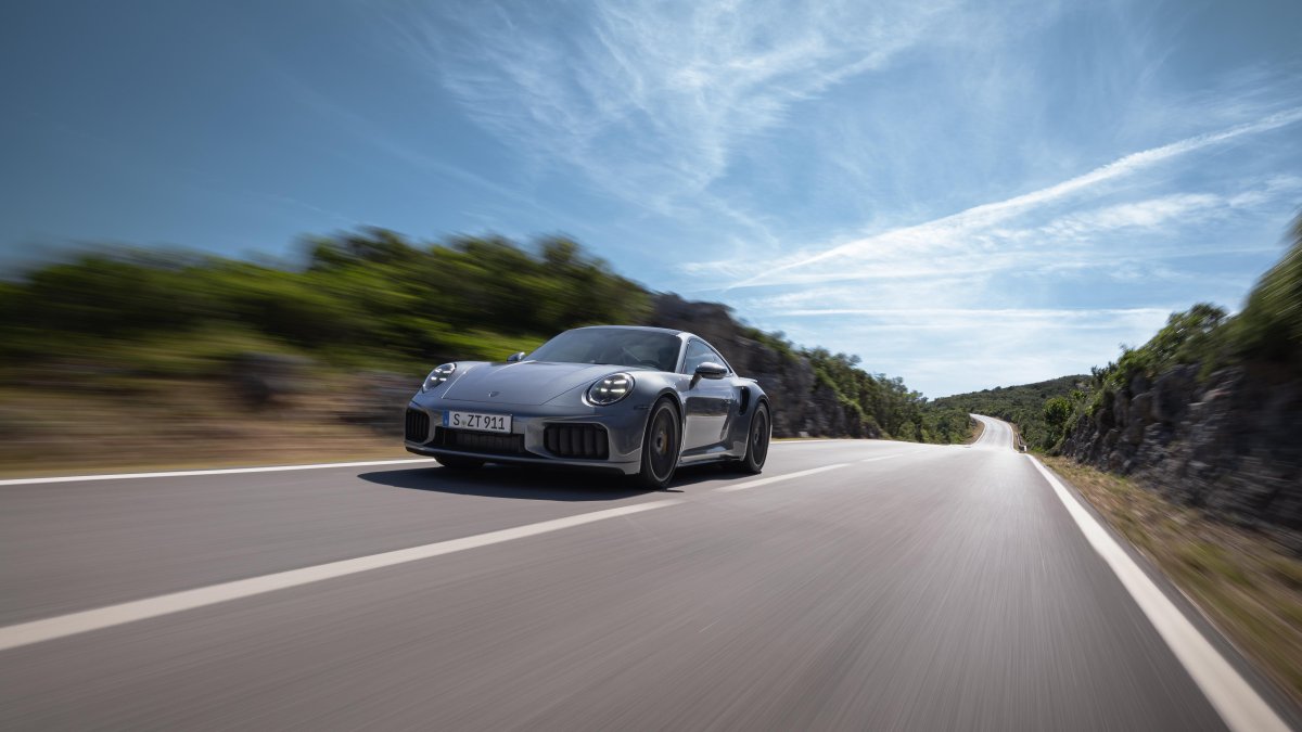Yolda ilerleyen gri bir Porsche 911 modelinin önden görünümü